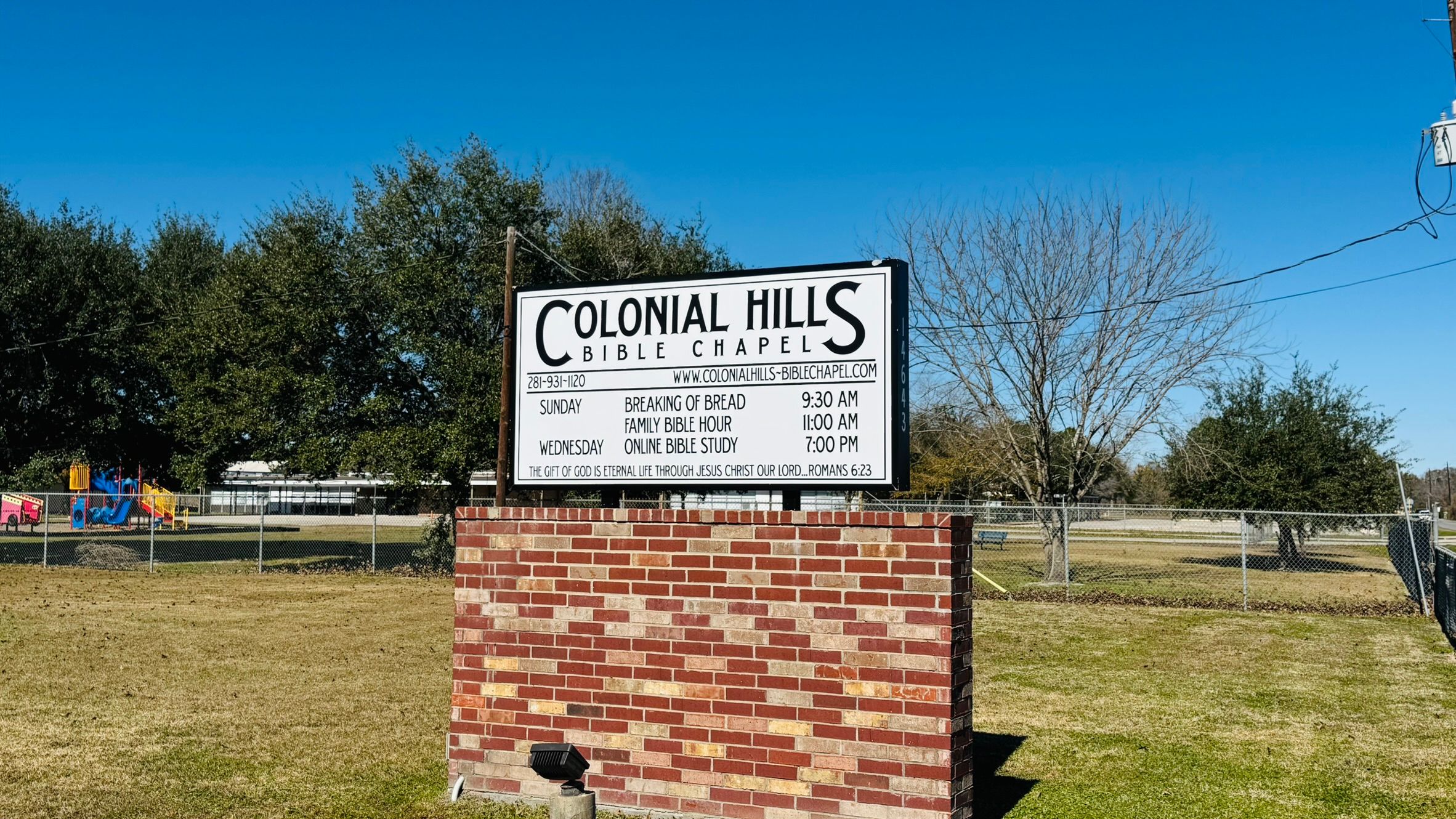 The Colonial Hills Bible Chapel sign under a clear blue sky